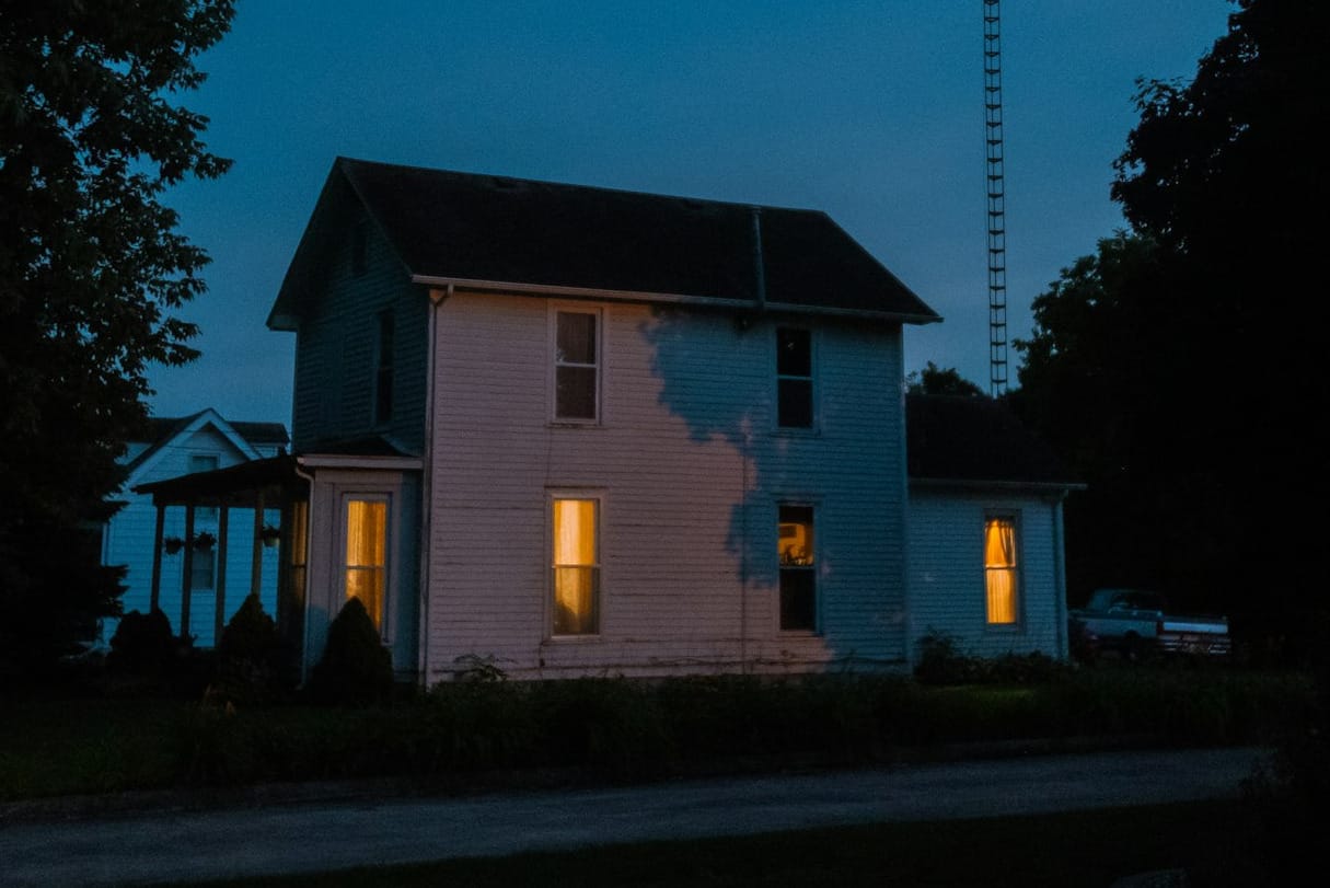 a house is lit up at night with the lights on